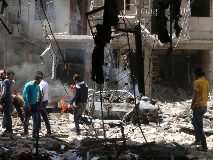 People inspect the damage at a site hit by airstrikes, in the rebel-held area of Aleppo's Bustan al-Qasr