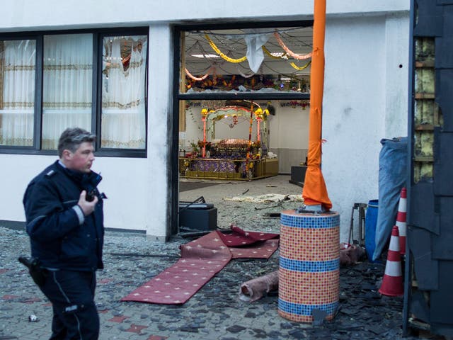 A police officer walks past the scene of the blast at the Gudawara in Essen, Western Germany