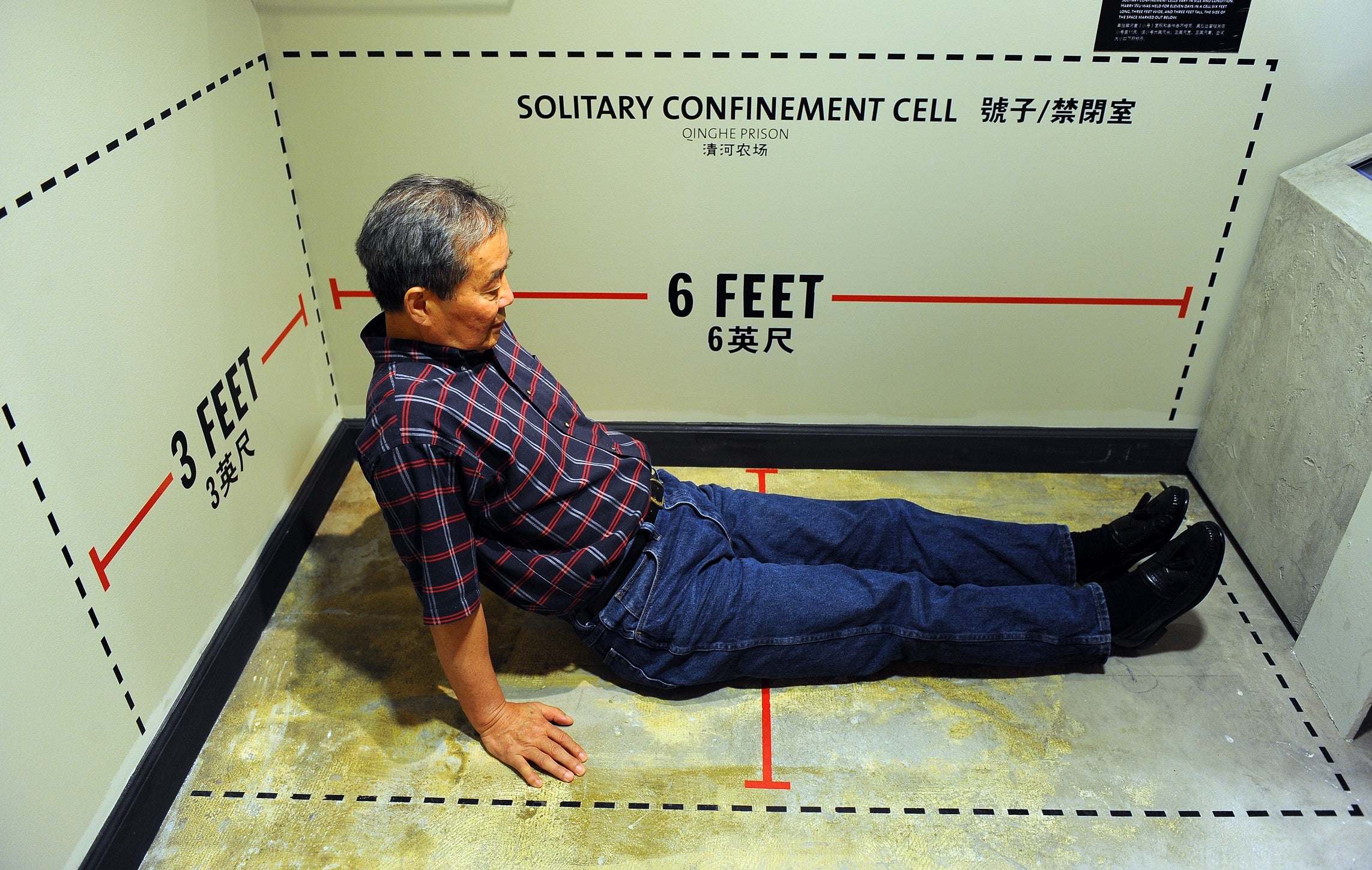 Harry Wu sits in an exhibit showing the exact dimensions of his solitary confinement cell where he spent 11 days at the labor prison camp which is on display at the Laogai Museum on June 20, 2011 in Washington, D.C.