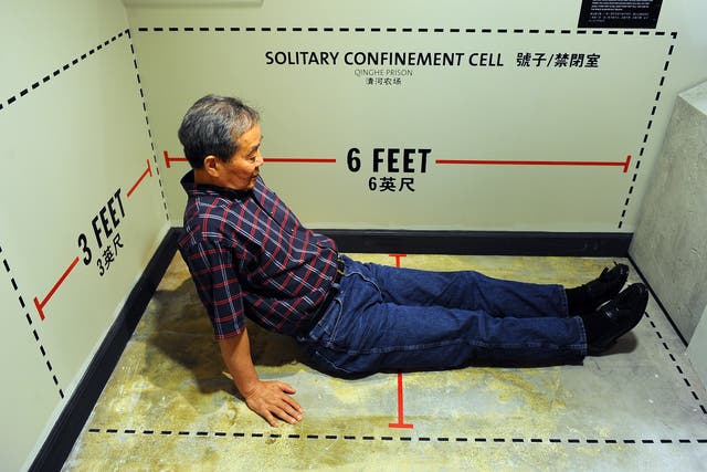 Harry Wu sits in an exhibit showing the exact dimensions of his solitary confinement cell where he spent 11 days at the labor prison camp which is on display at the Laogai Museum on June 20, 2011 in Washington, D.C.