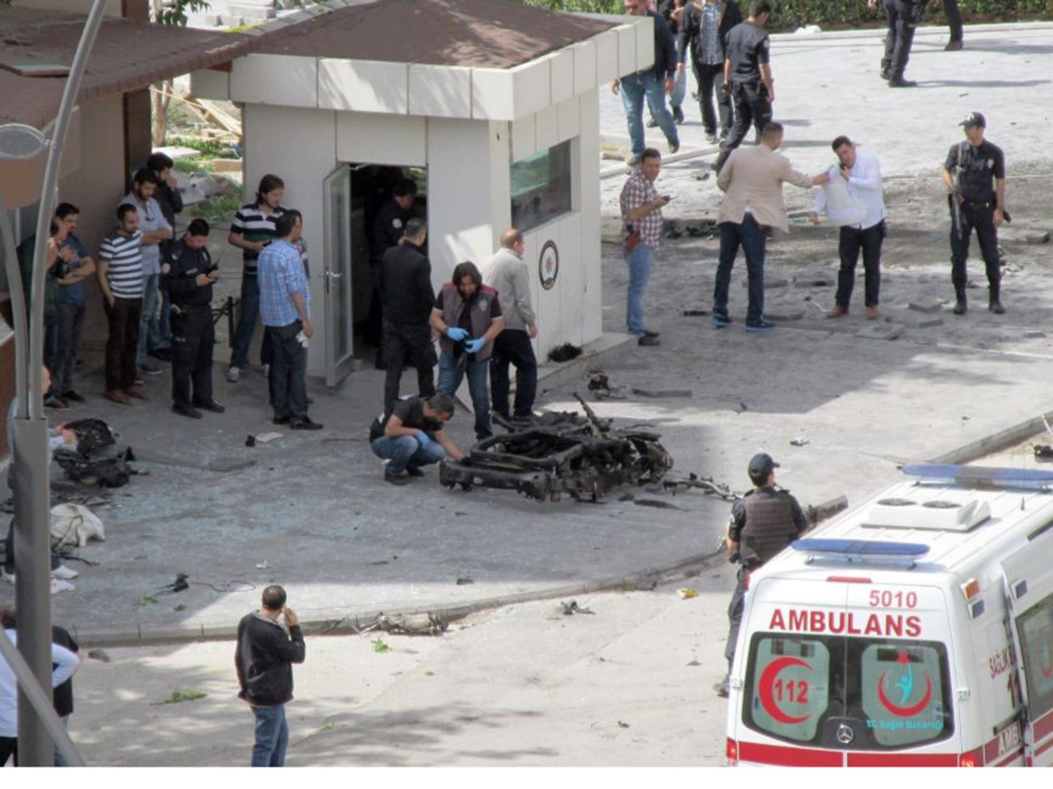 People inspecting the remains of the bombed out car outside Gaziantep police station