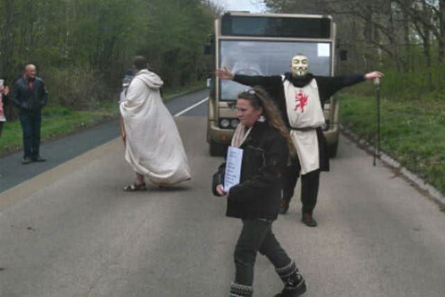 A druid protests in front of one of English Heritage's coaches