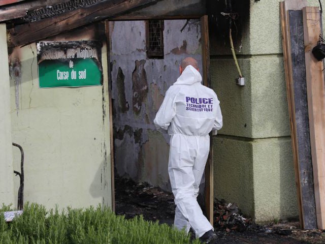 A police officer inspects a Muslim prayer room set on fire