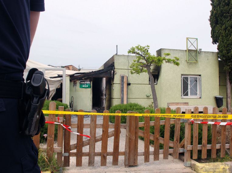 A French police officer stands in front of a Muslim prayer room after it was destroyed by a fire