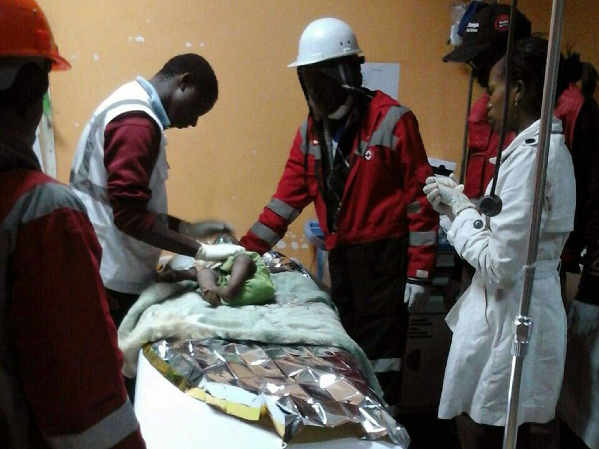 Kenyan Red Cross staff with a 18-month-old toddler rescued alive from the rubble of a six-storey building on May 2