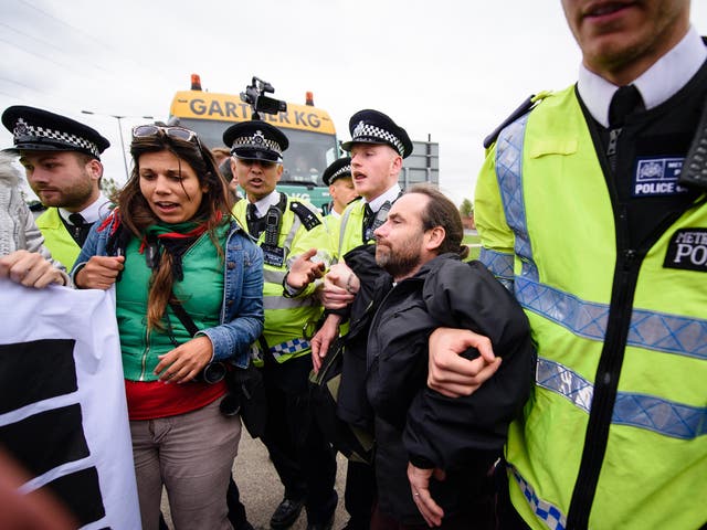 Protesters are removed by police after taking part in a road block outside the DSEI arms fair in 2015