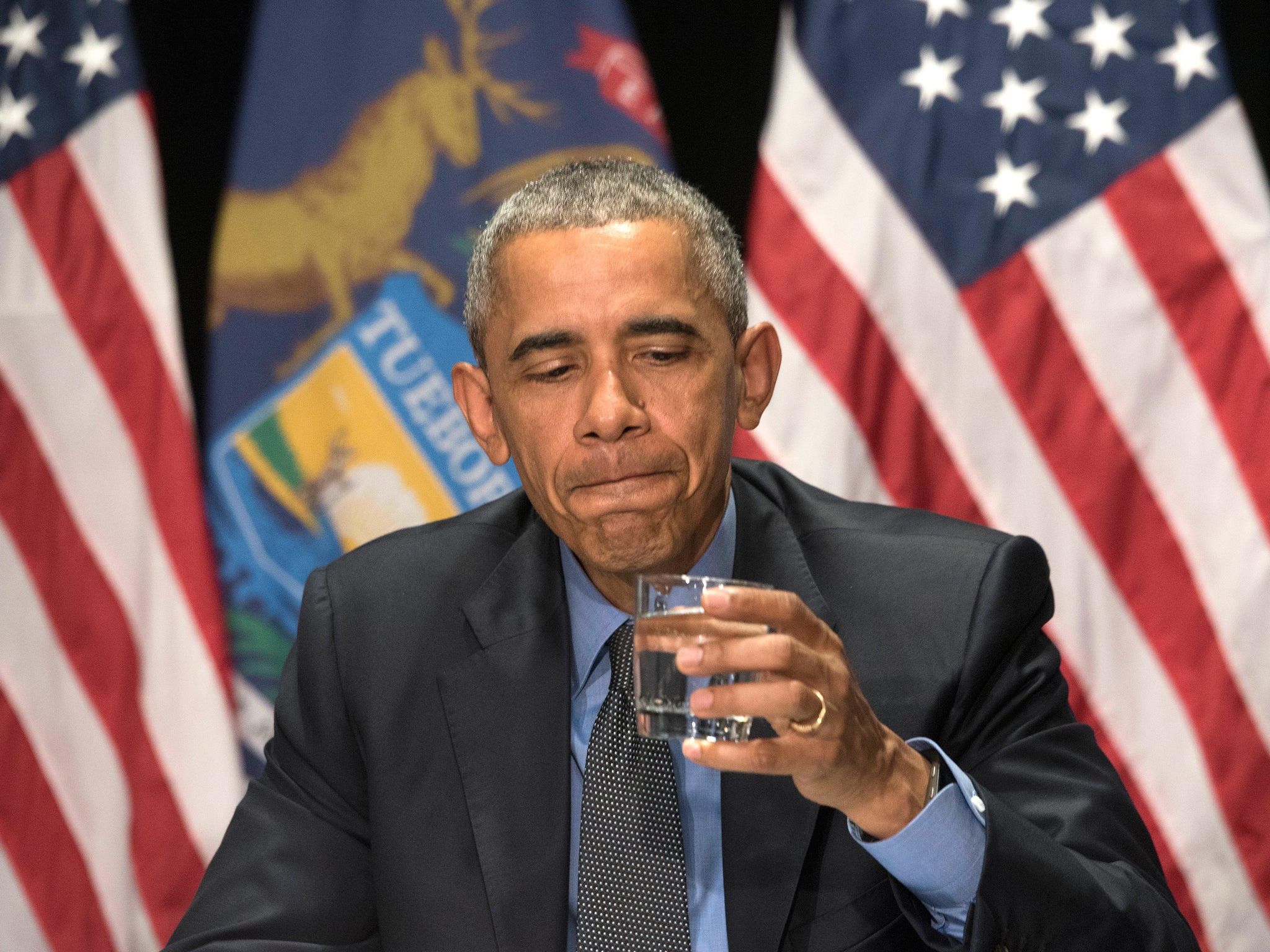 Mr Obama takes a sip of filtered Flint water to encourage residents AP
