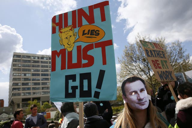 A junior doctor wears a mask bearing the face of Health Secretary Jeremy Hunt during a strike outside St Thomas' Hospital in London,