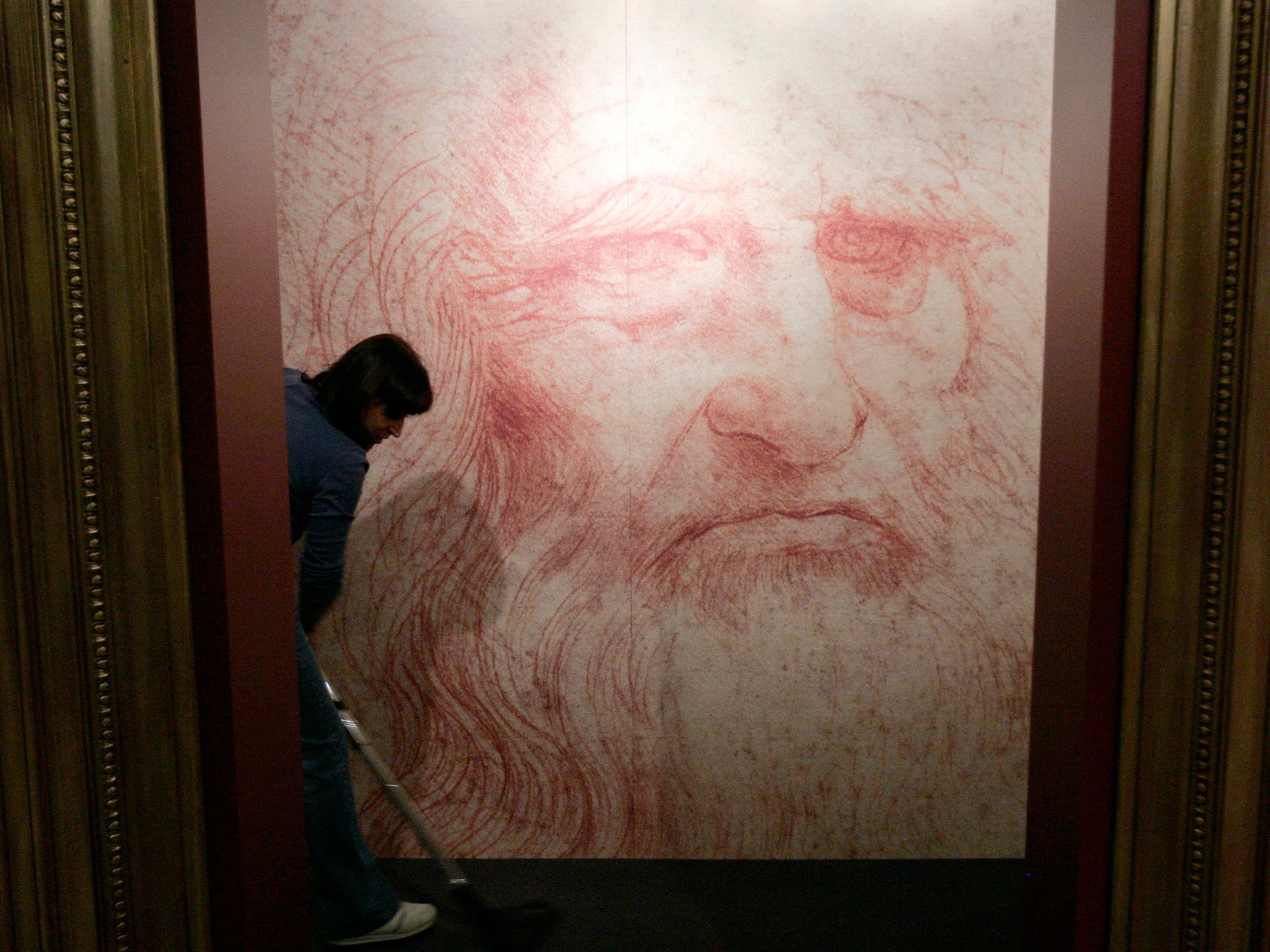 A cleaner vacuums in front of a Leonardo da Vinci self-portrait drawn around 1515 or 1516 at an exhibition in Brussels
