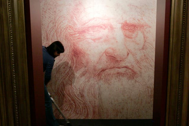 A cleaner vacuums in front of a Leonardo da Vinci self-portrait drawn around 1515 or 1516 at an exhibition in Brussels