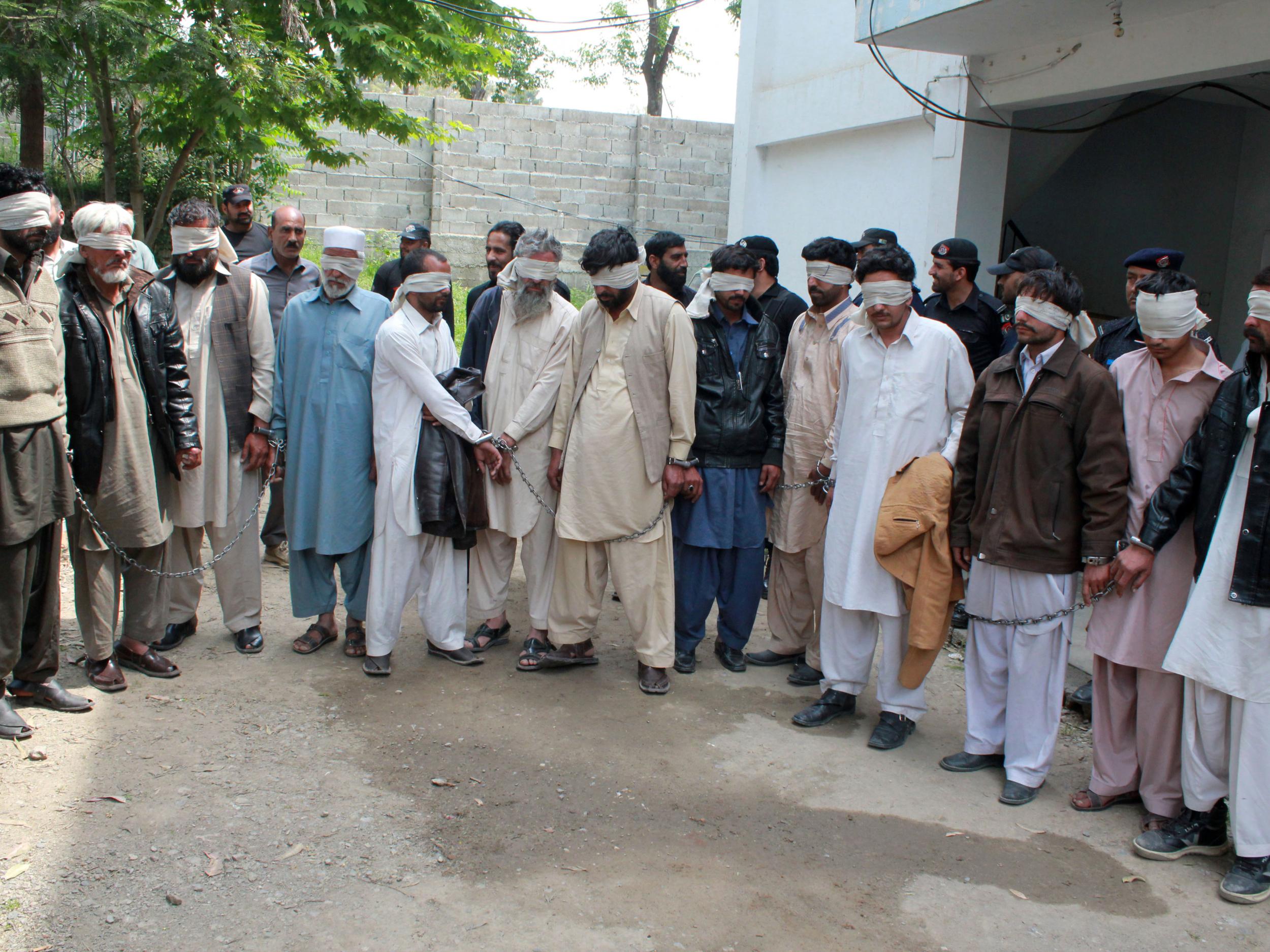 Members of a tribal council accused of ordering the burning death of a 16-year-old girl are shown to the media after they were arrested by police in Abbottabad, Pakistan