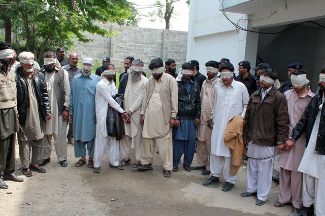 Members of a tribal council accused of ordering the burning death of a 16-year-old girl are shown to the media after they were arrested by police in Abbottabad, Pakistan