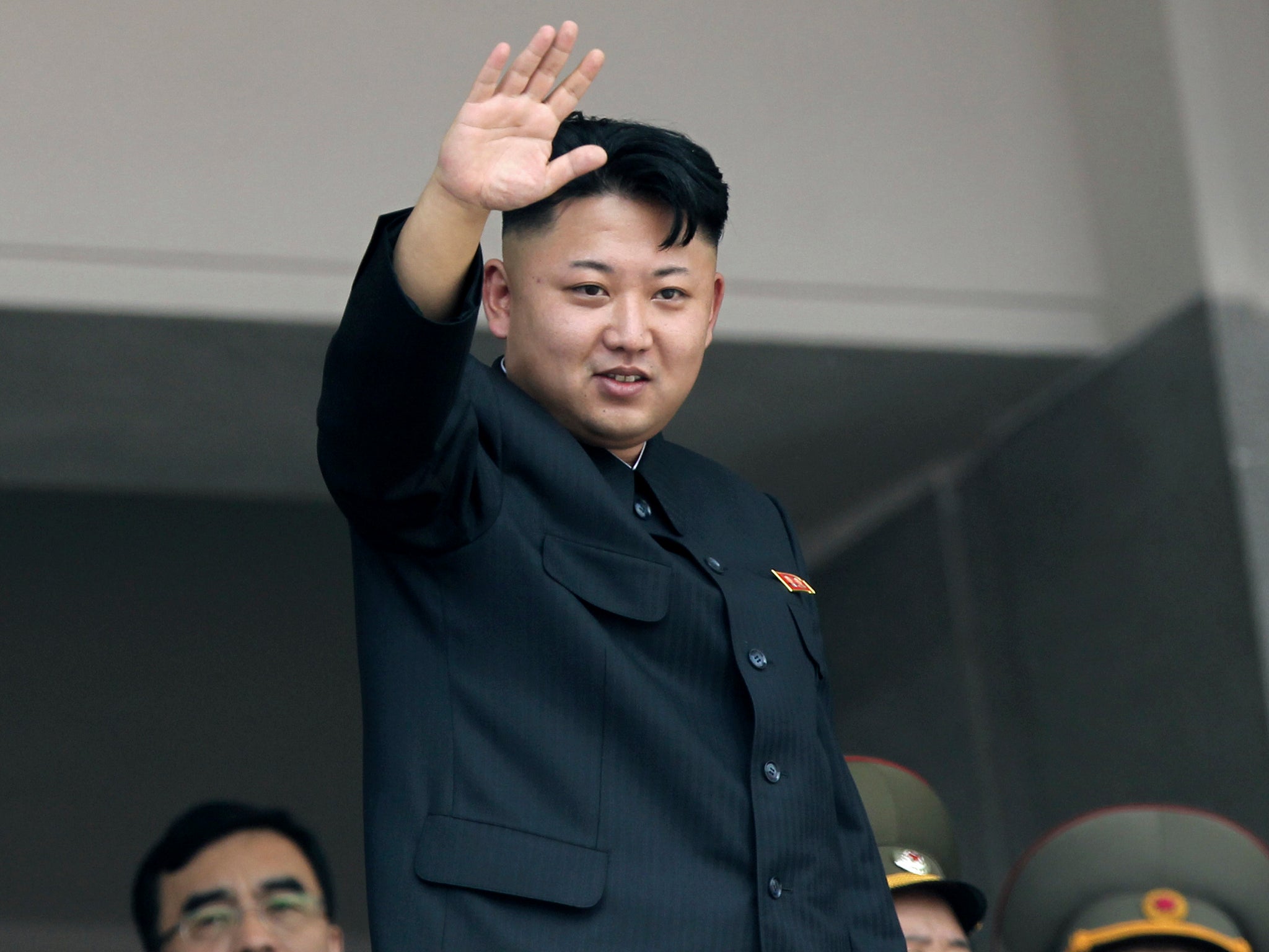 Kim Jong-un waves to spectators during a 2013 military parade