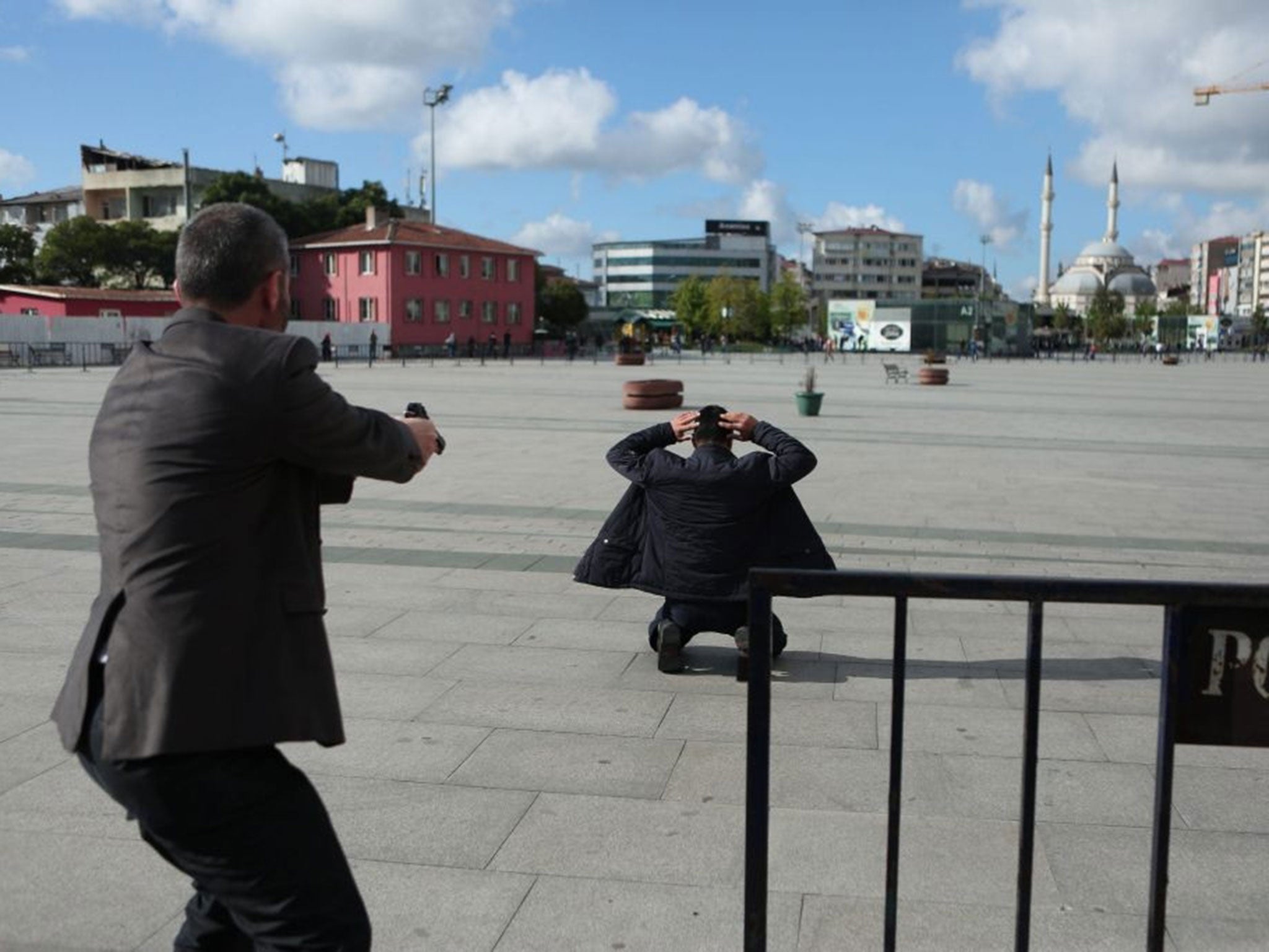 A handout picture provided by Cumhuriyet newspaper shows a policeman point his gun at Murat Sahin after he attempted to attack Can Dundar in front of the Courthouse in Istanbul, Turkey, 6 May, 2016