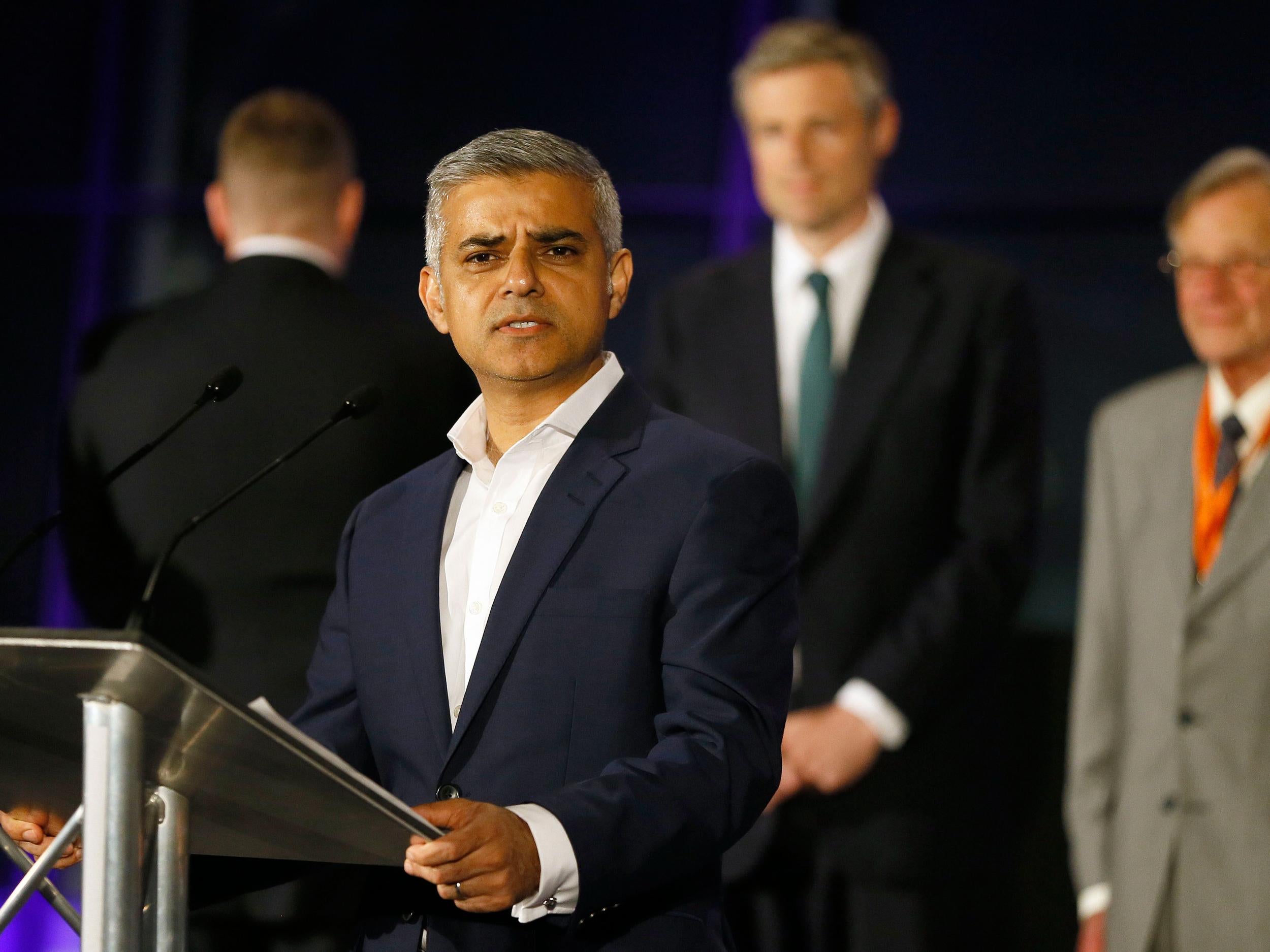 A tired Sadiq Khan speaks at City Hall after being confirmed as the new London Mayor - with Paul Golding, to his left, turning his back