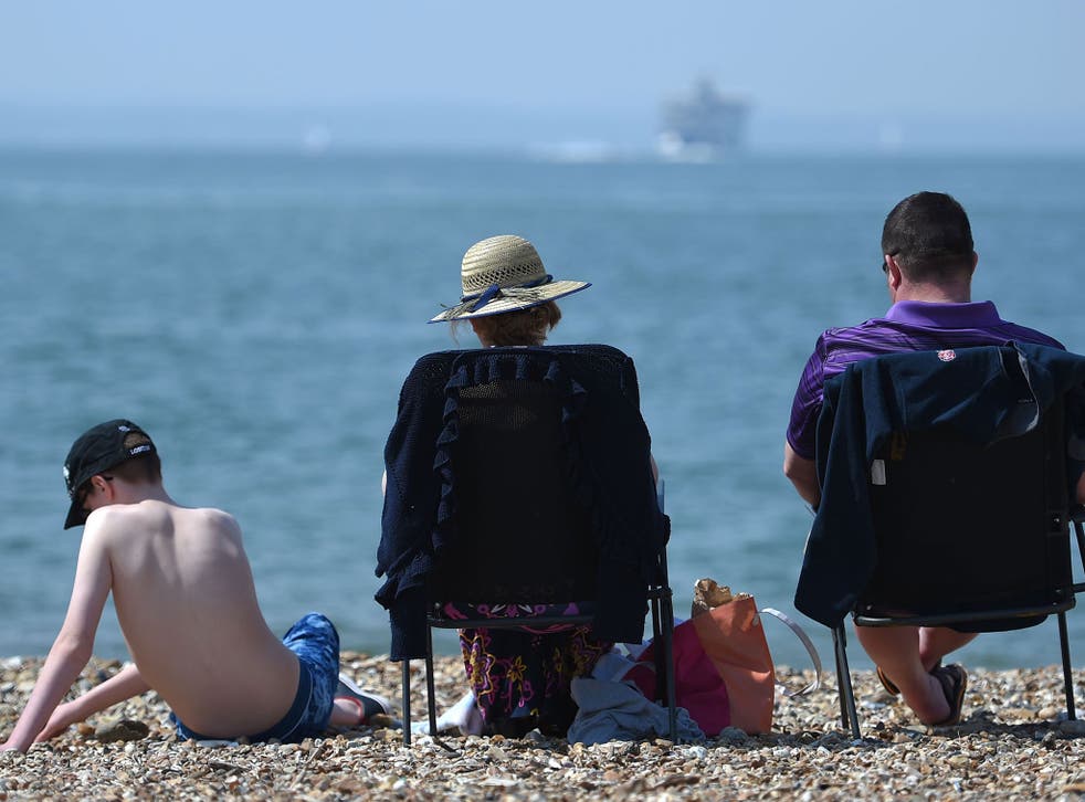 Sunbathers enjoy the warm weather on Southsea beach, Portsmouth, on May 7, 2016.