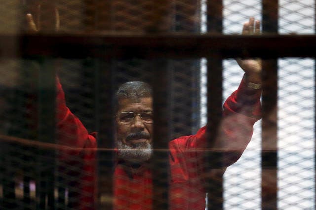Mohamed Mursi at a court appearance in Cairo last year