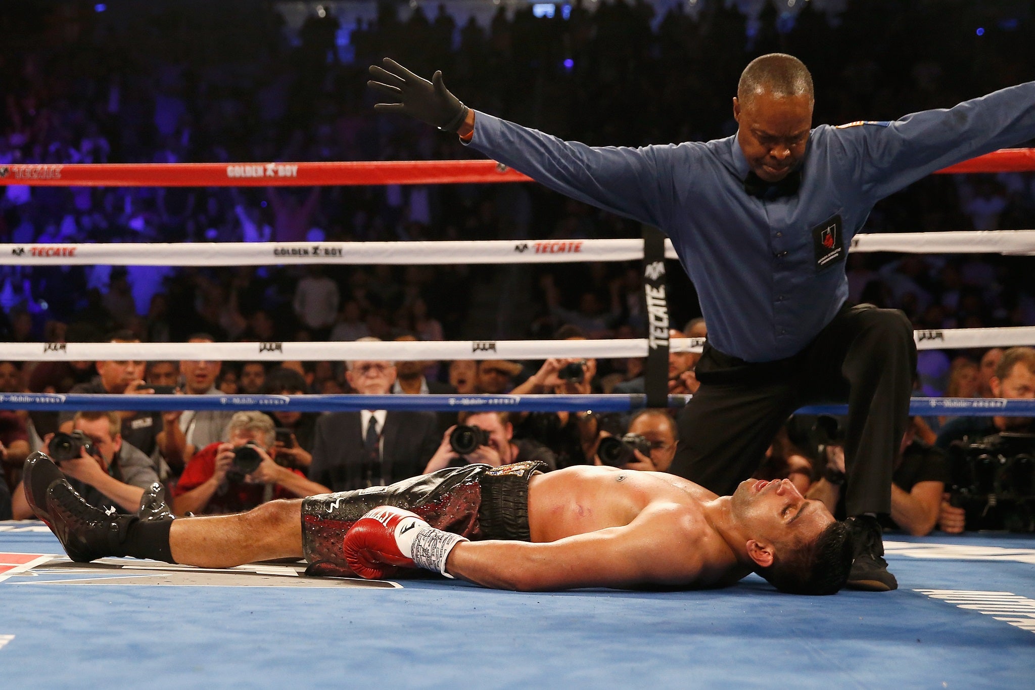 Referee Kenny Bayless waves off the fight as Khan is knocked out