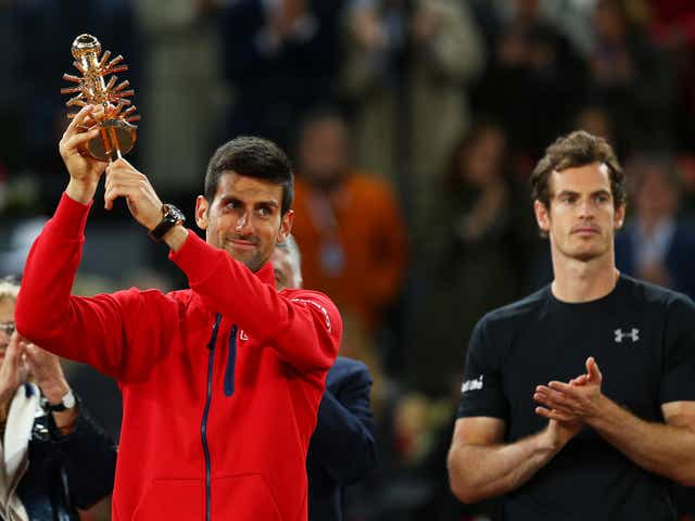 Djokovic holds aloft his winners trophy after his three set victory against Murray
