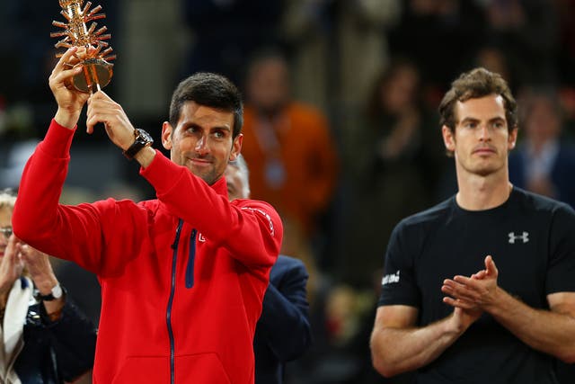Djokovic holds aloft his winners trophy after his three set victory against Murray