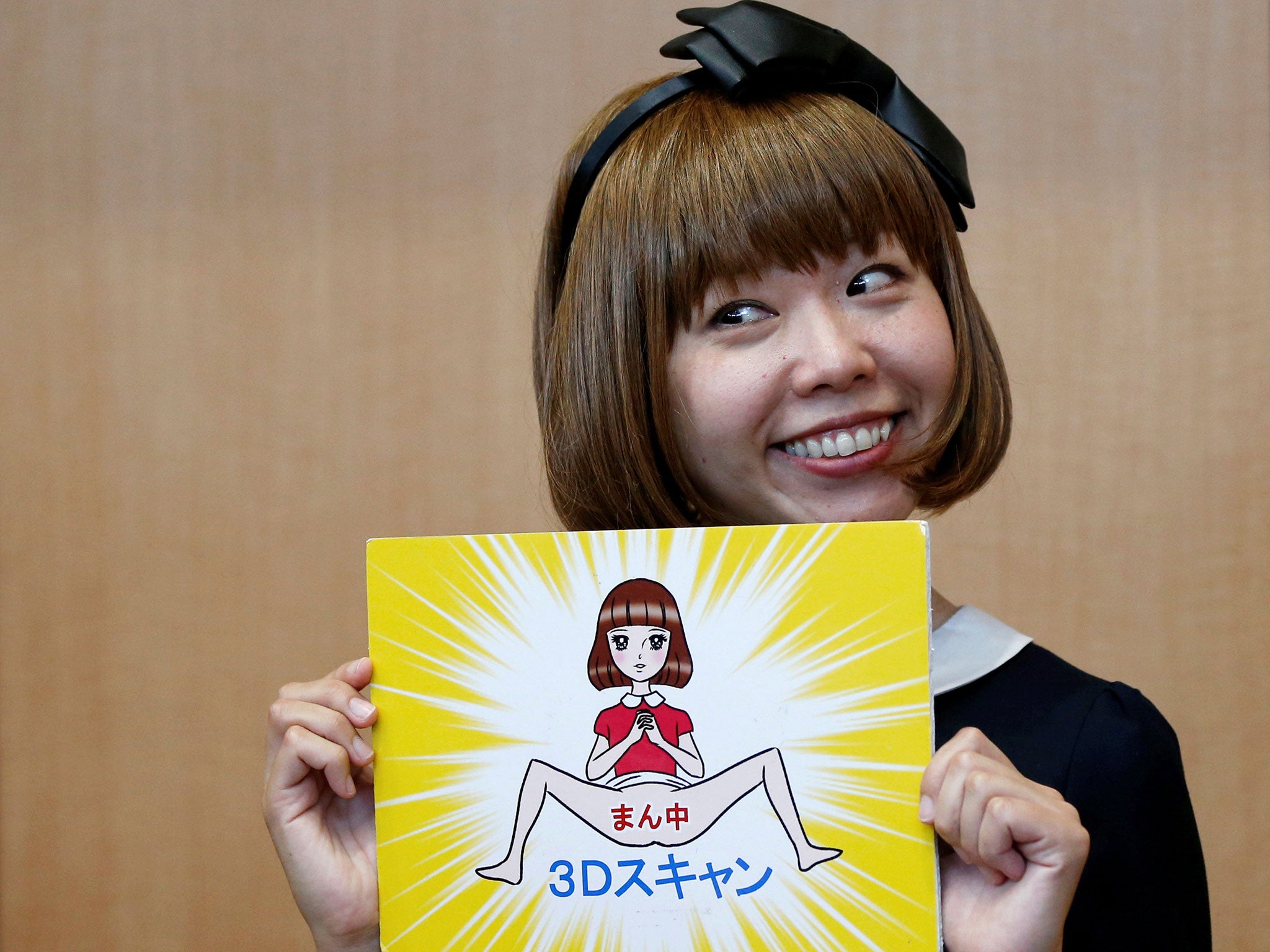 Japanese artist Megumi Igarashi, known as Rokudenashiko, holds her artwork after a news conference following a court appearance in Tokyo