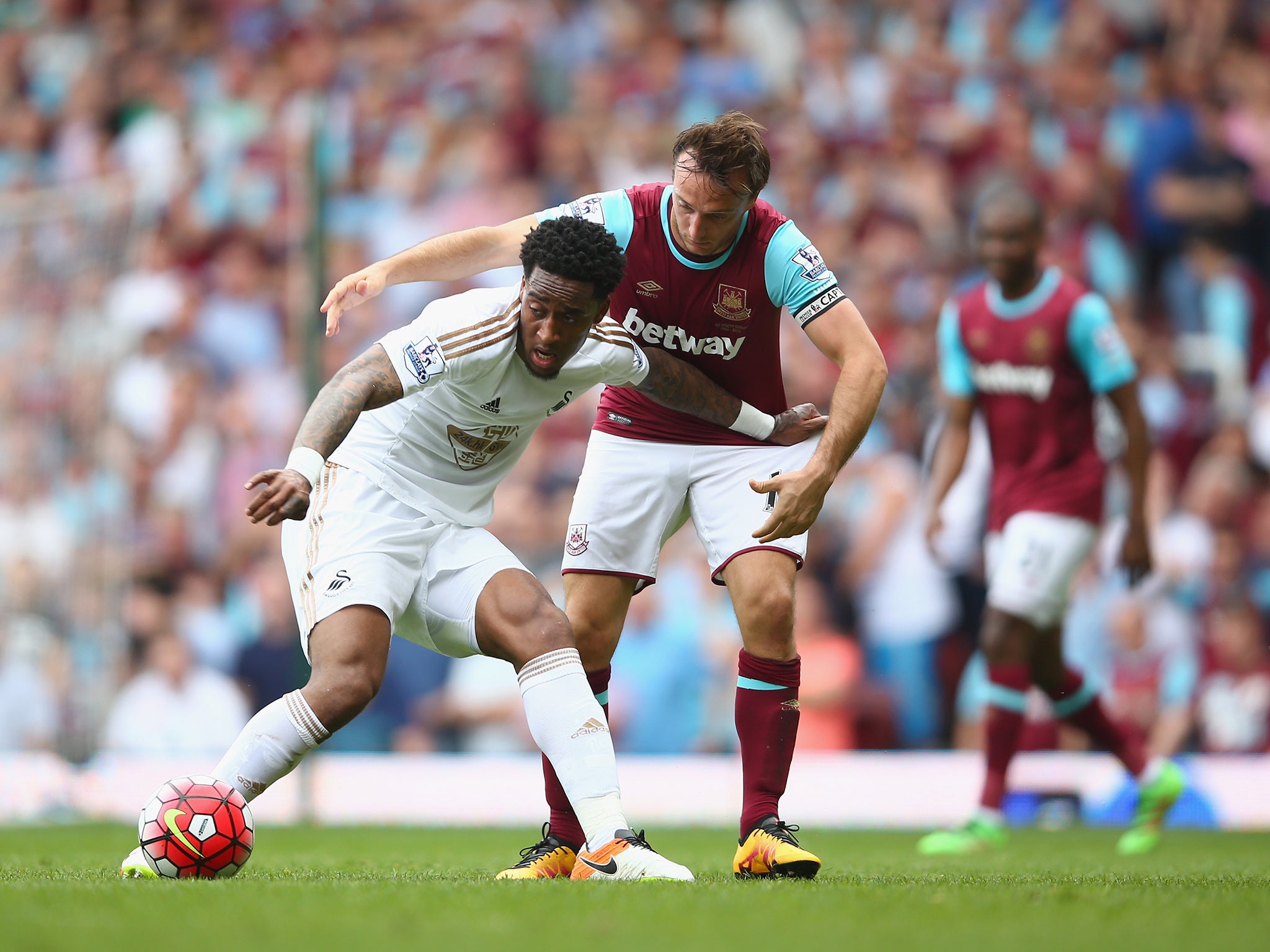 Noble battles with Bony for the ball during West Ham's defeat by Swansea