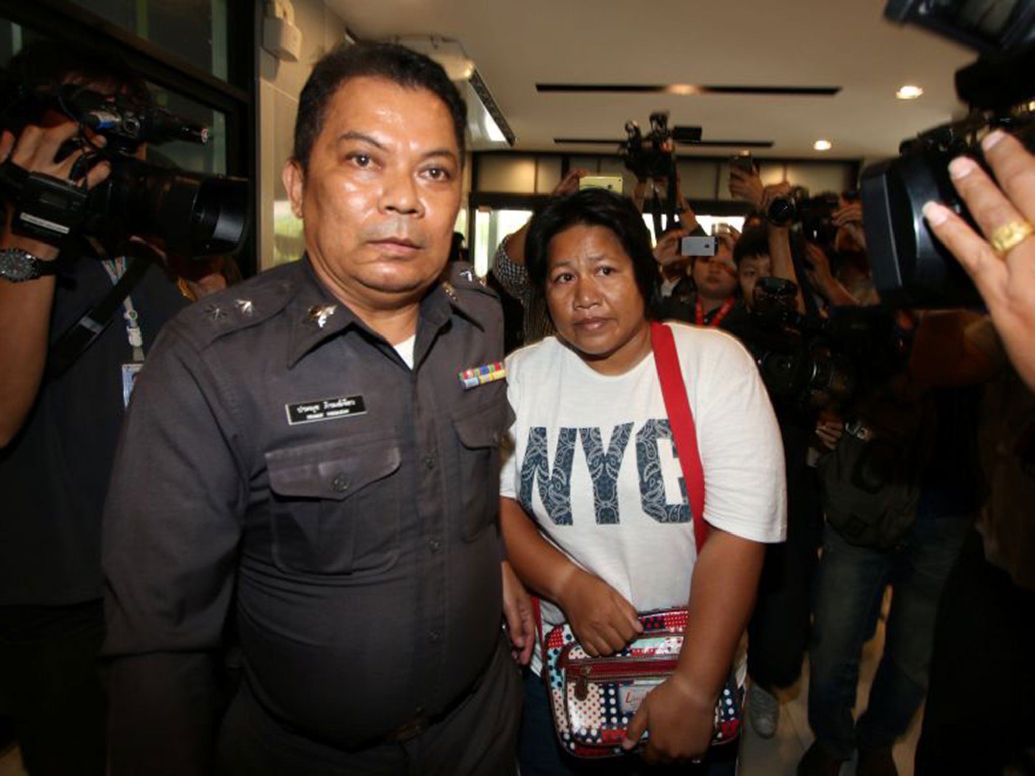 Patnaree Chankij is escorted by police as she arrives at a military court in Bangkok