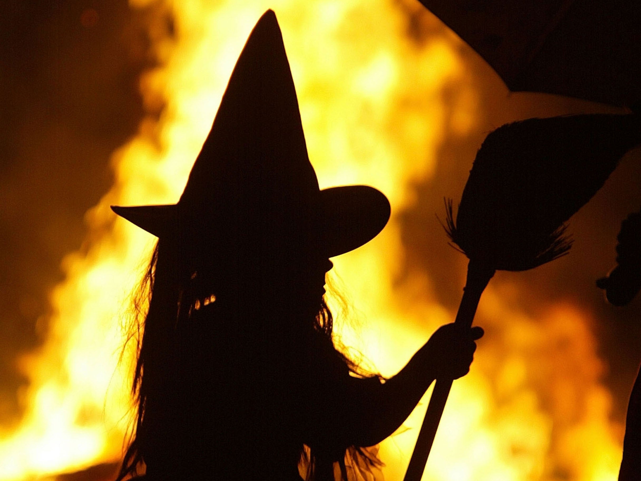 A girl dressed as a witch stands by a Halloween bonfire in Maryland in 2005