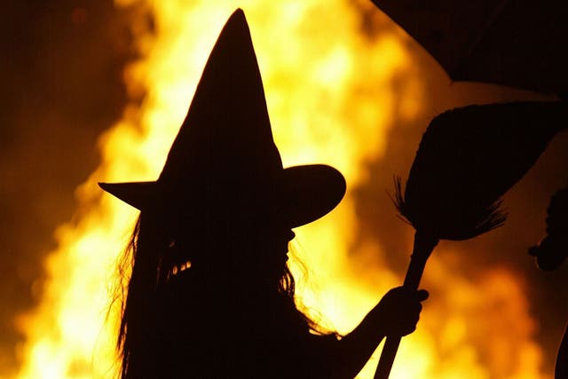 A girl dressed as a witch stands by a Halloween bonfire in Maryland in 2005