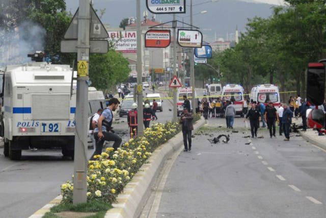 Security officers gather at the scene following a vehicle explosion near a military facility in Istanbul
