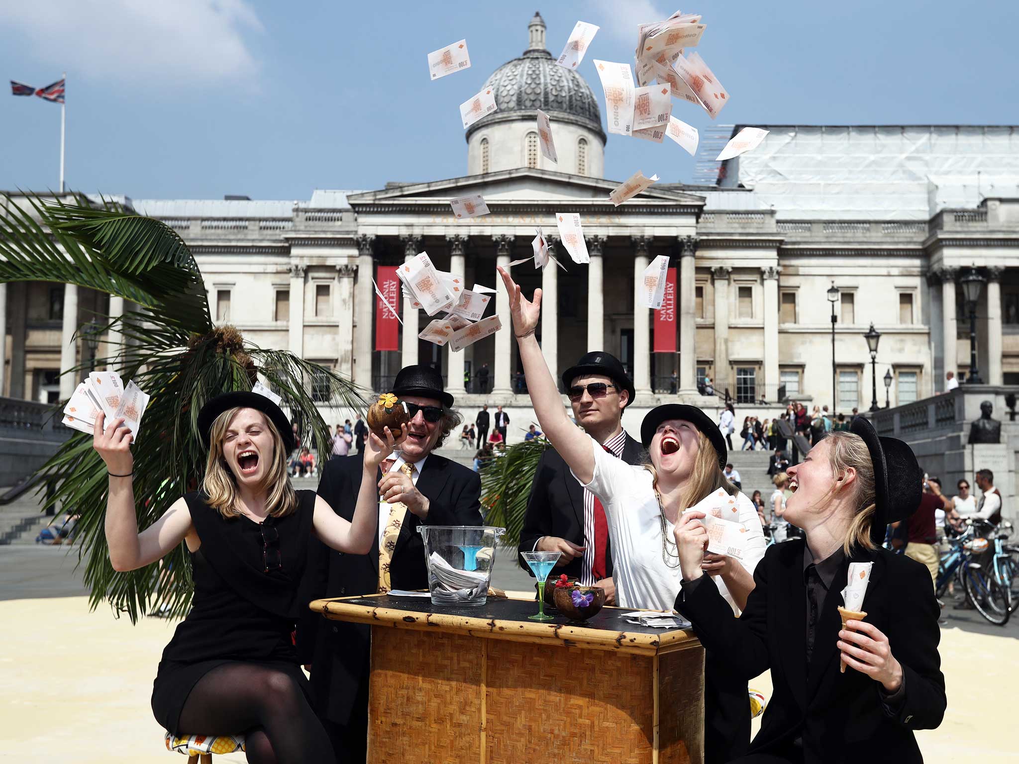 Protesters throw fake money as they take part in a demonstration against tax havens in London. The protest, organised by Oxfam, ActionAid and Christian Aid, turned part of Trafalgar Square into a 'tropical tax haven' to highlight tax dodging as an international corruption summit hosted by David Cameron was held in nearby Lancaster House