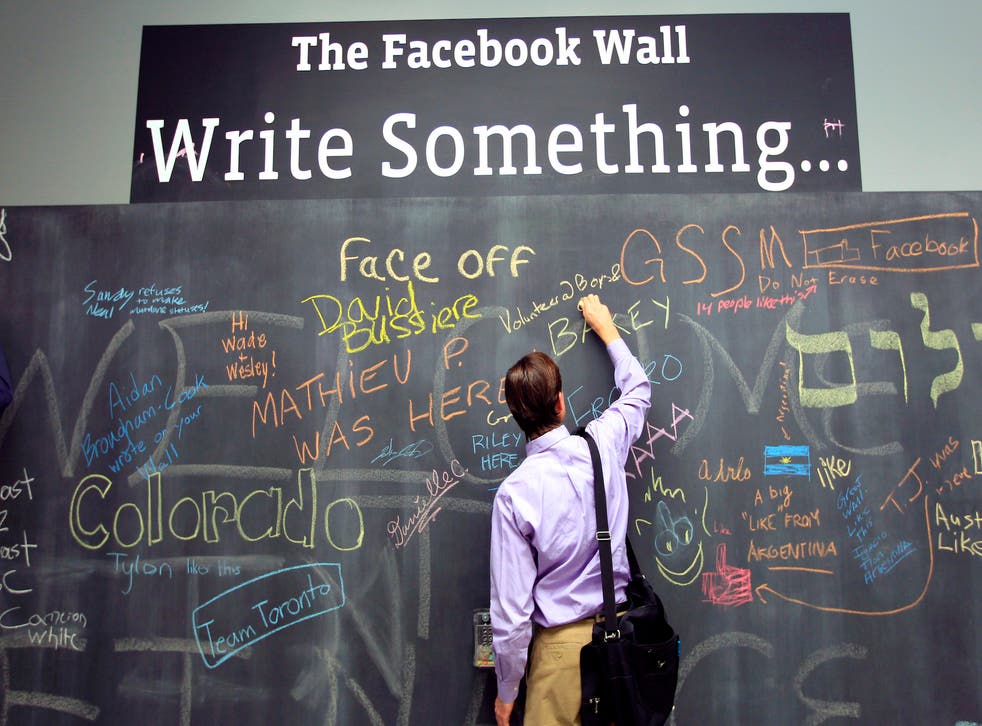 An employee writes a note on the message board at the new headquarters of Facebook in Menlo Park, California January 11, 2012