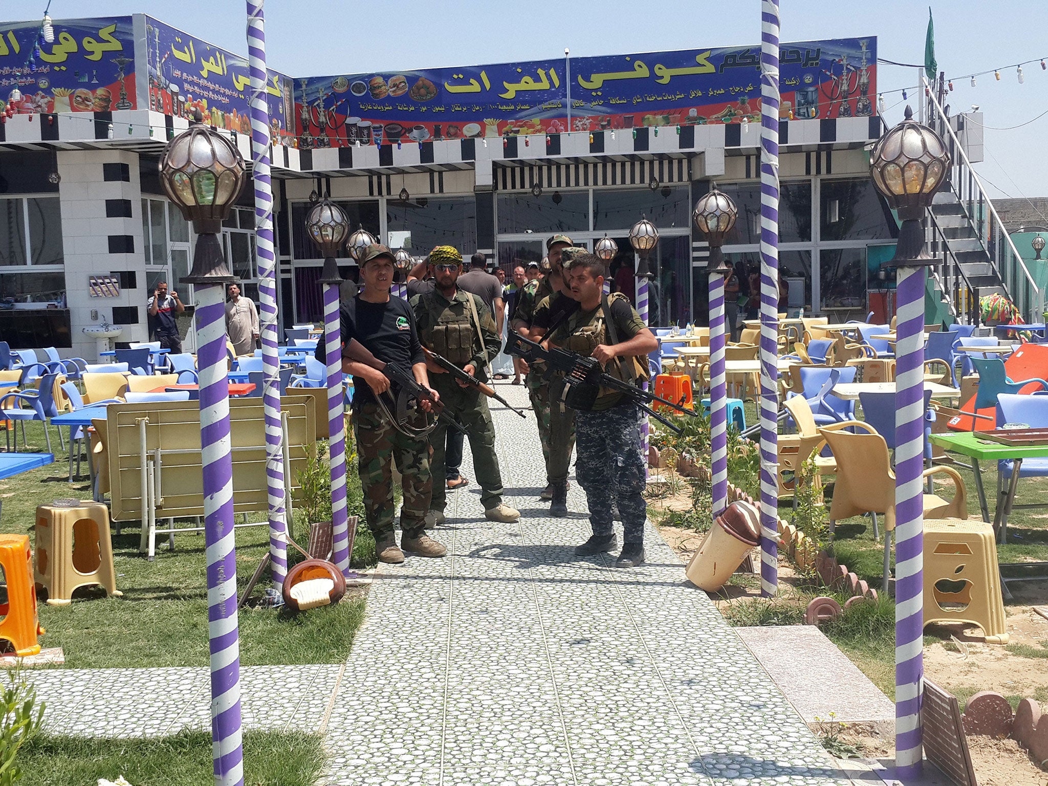 Shia militia members outside a cafe after an attack in Balad, Iraq, May 13 2016.