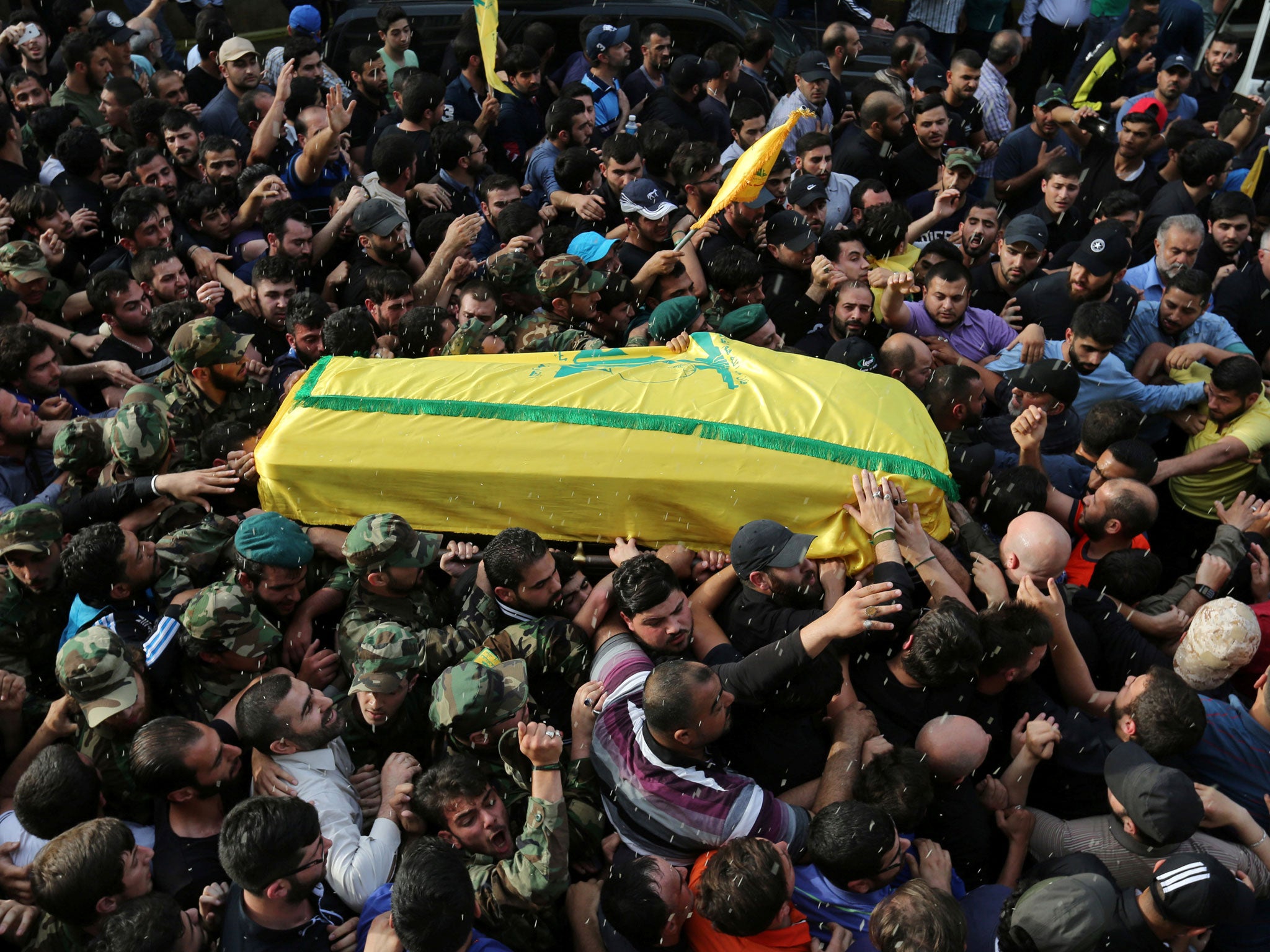 Rice is thrown as Hezbollah members carry the coffin of top Hezbollah commander Mustafa Badreddine, who was killed in an attack in Syria, during his funeral in Beirut's southern suburbs
