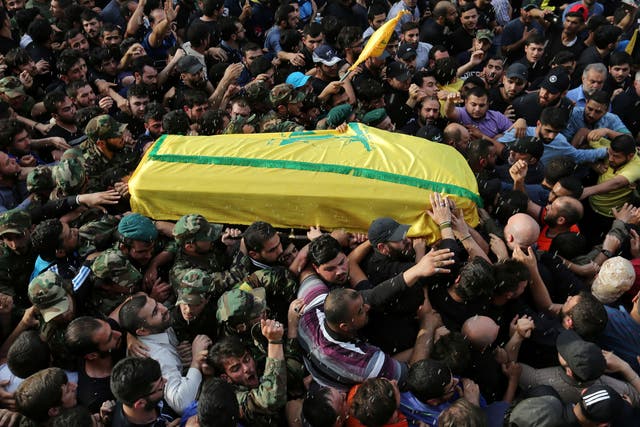 Rice is thrown as Hezbollah members carry the coffin of top Hezbollah commander Mustafa Badreddine, who was killed in an attack in Syria, during his funeral in Beirut's southern suburbs