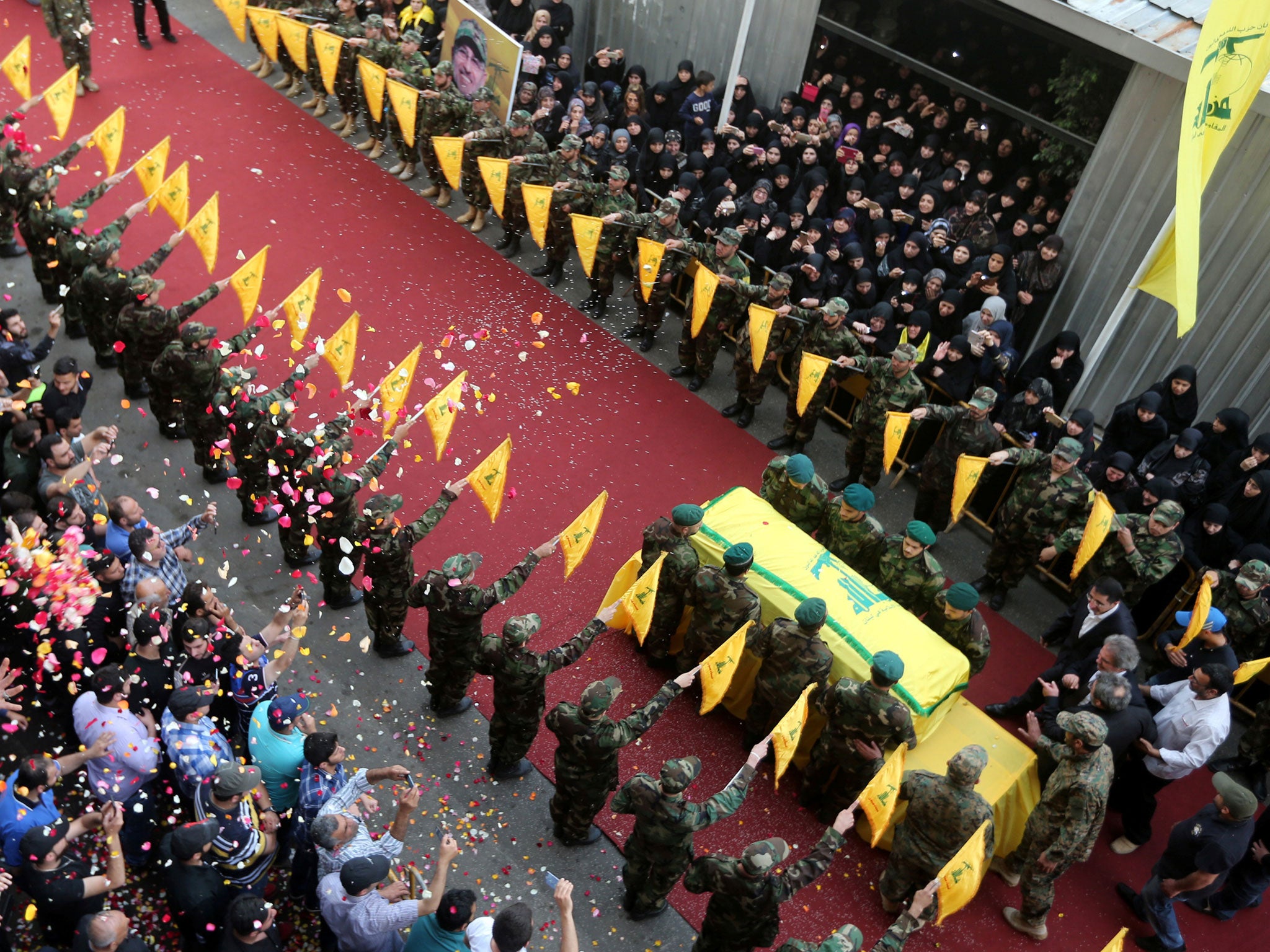 People toss rose petals as Hezbollah members stand near the coffin of top Hezbollah commander Mustafa Badreddine, who was killed in an attack in Syria, during his funeral in Beirut's southern suburbs, Lebanon, May 13, 2016.