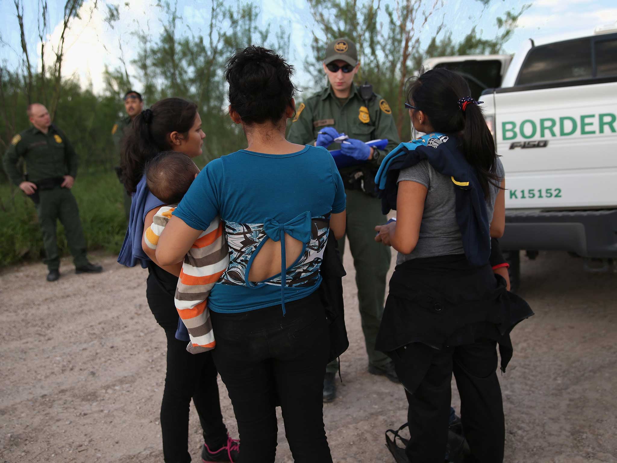 Immigrants from central America turn themselves in to US Border Patrol agents after crossing the Rio Grande River from Mexico