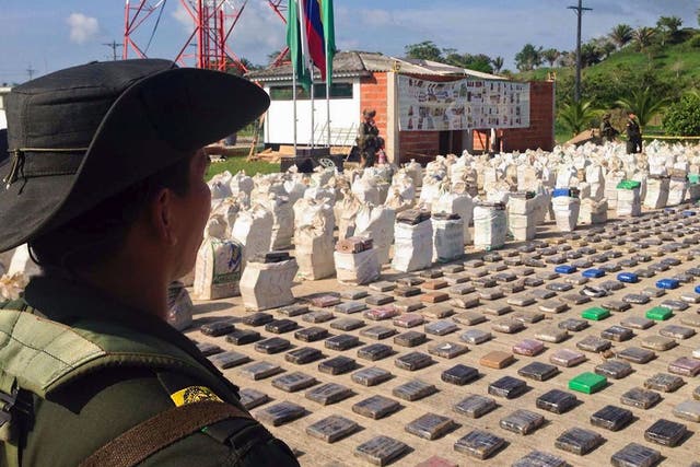 A Colombian police officer standing guard over eight tons of seized cocaine in Turbo
