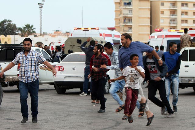 Libyans fleeing shelling at protest in Benghazi. Protesters were calling for Libyan forces to recapture the southern city of Sirte