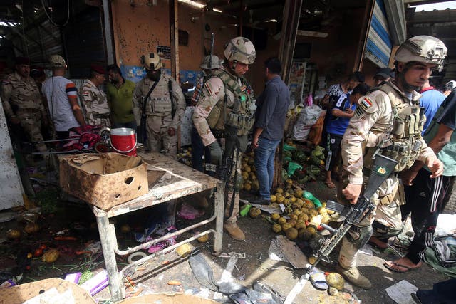 Iraqi security forces gather at the site of a suicide bombing in the Shaab area in northern Baghdad on May 17, 2016.