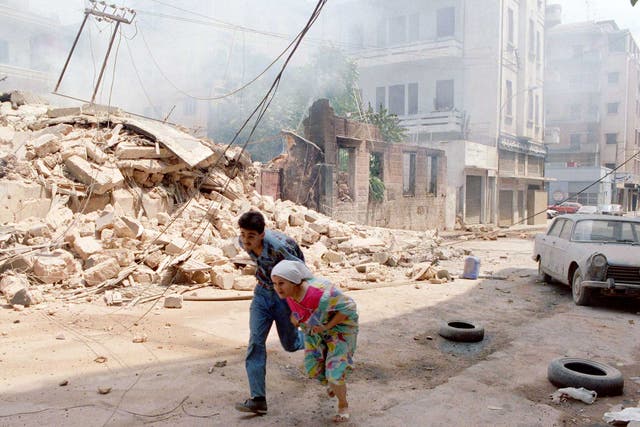 A Lebanese woman and son run through west Beirut under shellfire, August 1989