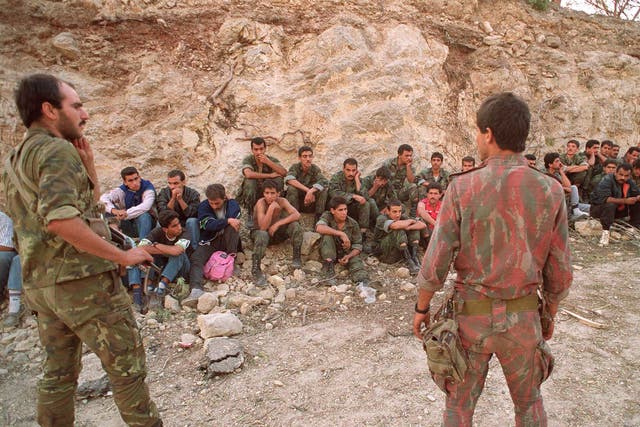 Two Syrian soldiers guard a group of prisoners in Beirut, October 1990 