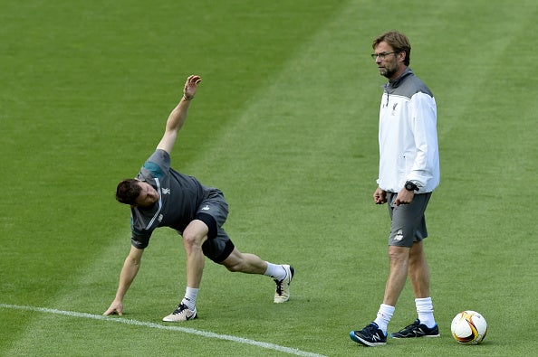 James Milner limbers up on the St Jakob-Park pitch in front of Liverpool manager Jurgen Klopp (Getty)