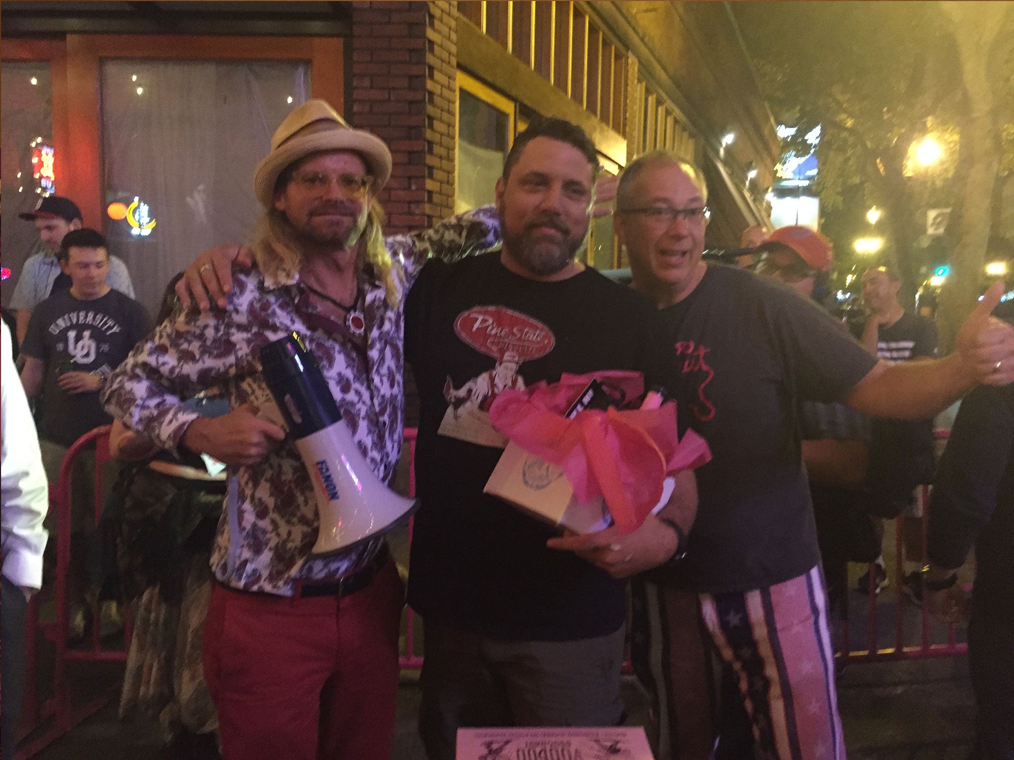 Voodoo Doughnuts founder Tres Shannon (left) with mayoral doughnut-eating contest winner Sean Davis (centre)