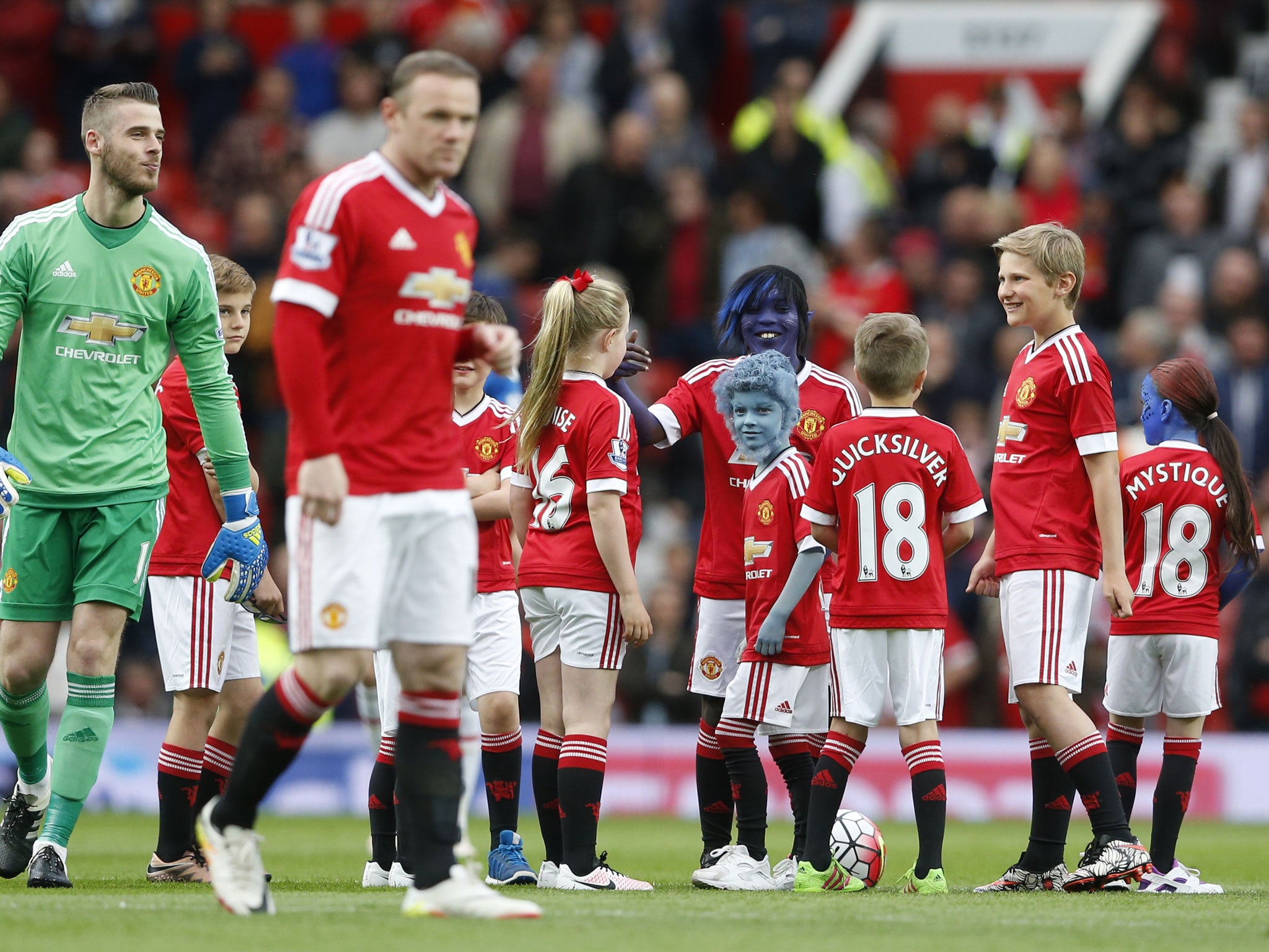 Wayne Rooney and David De Gea take to the pitch with the blue-faced mascots at Old Trafford on Tuesday night (Reuters).