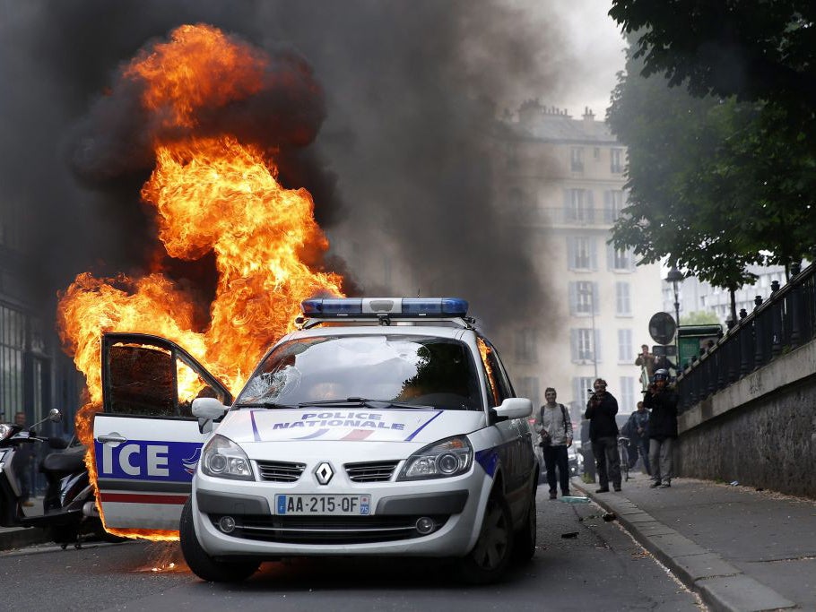 A burning police car that was set on fire by protestors during clashes as part of a demonstration, that had been banned, against police violence