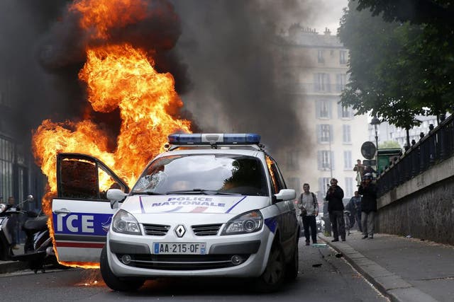 A burning police car that was set on fire by protestors during clashes as part of a demonstration, that had been banned, against police violence