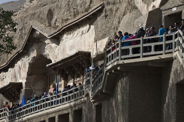 Tourists queue to enter the Mogao Grottoes during China's National Day holiday