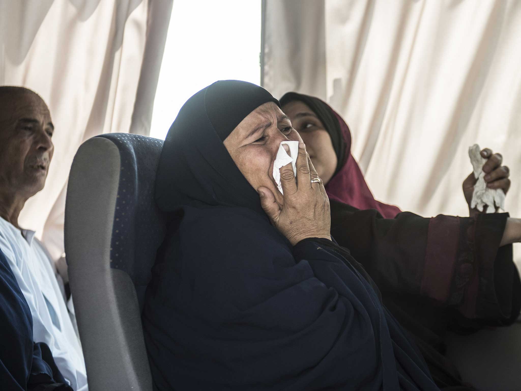 A relative of a passenger who was flying aboard an EgyptAir plane that vanished from radar en route from Paris to Cairo overnight cries as family members are transported by bus to a gathering point at Cairo airport