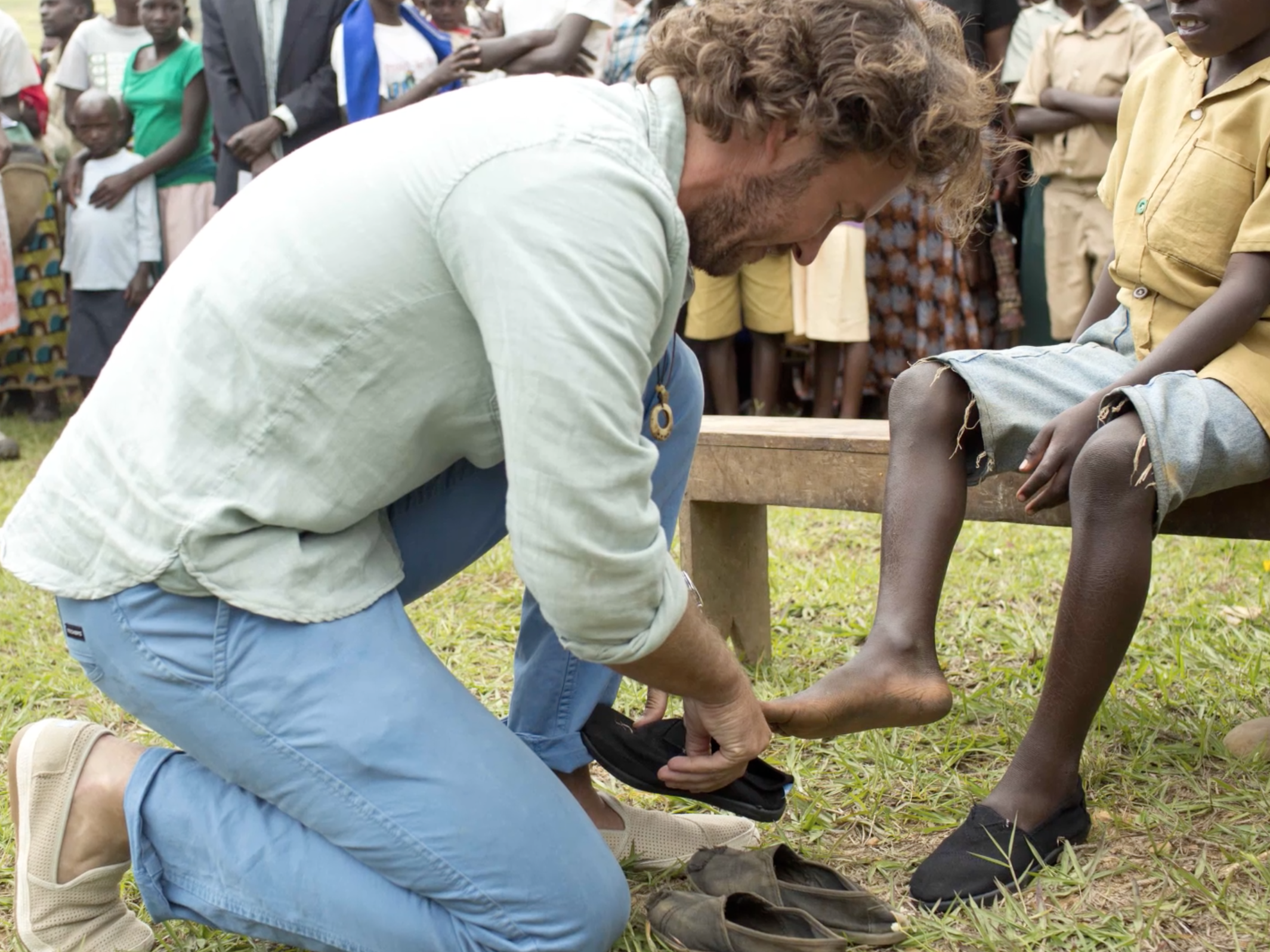Blake Mycoskie donating shoes in Africa